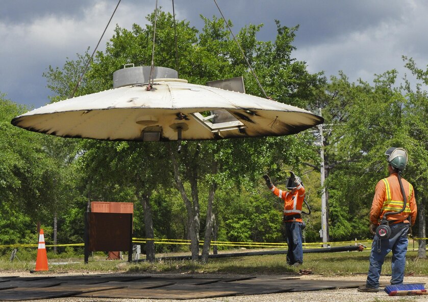 Construction crew members watch as the top of the former  water tower is lowered down at Duke Field, Fla. During demolition work, crews found a nameplate attached that indicated the 70,000-gallon water tank was originally erected in 1942, predating the passing of the base's namesake, 1st Lt. Robert L. Duke, who was killed the following year.  (U.S. Air Force photo/Dan Neely)  