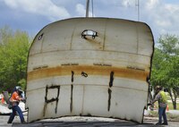 Construction crew members set down a side panel of a former water tower at Duke Field, Fla. During demolition work, crews found a nameplate attached that indicated the 70,000-gallon water tank was originally erected in 1942, predating the passing of the base's namesake, 1st Lt. Robert L. Duke, who was killed the following year.  (U.S. Air Force photo/Dan Neely)  