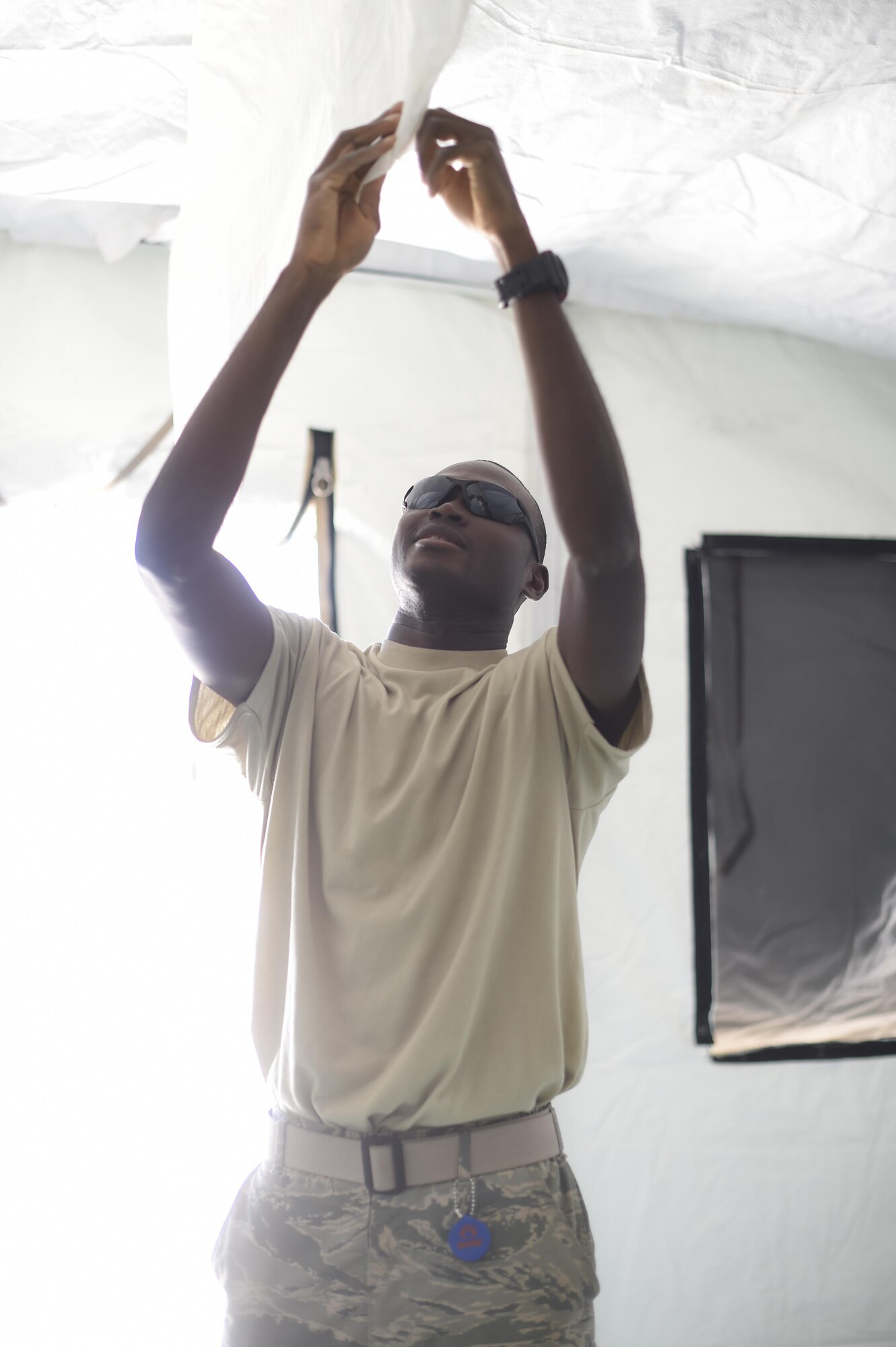 Airman 1st Class Moctar, 49th Civil Engineer Squadron installs air conditioning on the interior of a structure during a three day joint training exercise at Holloman Air Base, N.M. on June 7. Airmen from the 49th Materiel Maintenance Group and the 49th Civil Engineer Squadron work together to form the Base Expeditionary Airfield Resources team. The purpose of this exercise is to keep all Airmen trained and ready to set up and maintain worldwide deployable assets. (Last names being withheld due to operational requirements. U.S. Air Force Photo by Staff Sgt. Stacy Moless)