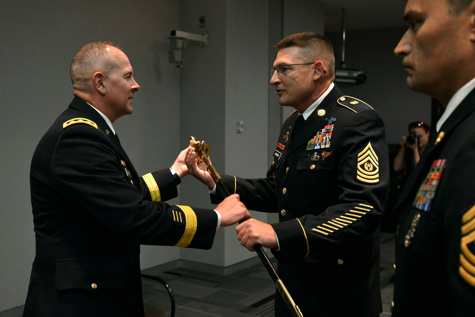 Army Lt. Gen. Timothy Kadavy, left, director of the Army Guard, passes the noncommissioned officer's sword to Command Sgt. Maj. Christopher Kepner, center, the incoming command sergeant major of the Army National Guard, during a Change of Responsibility Ceremony, June 8, 2016 in Arlington, Va. The passing of the NCO sword is a symbolic representation of the assumption of responsibilty. 