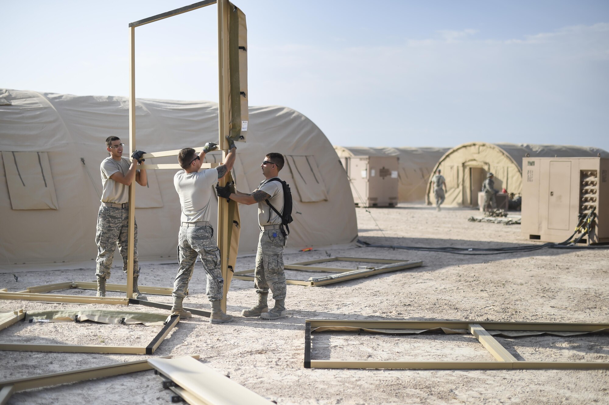 Airmen from the 49th Materiel Maintenance Group and the 49th Civil Engineer Squadron work together to build a structure during a three day joint training exercise at Holloman Air Base, N.M. on June 7. The Base Expeditionary Airfield Resources team is comprised of several Air Force specialties including aerospace ground equipment, structures, heating/air conditioning and electrical, as well as lodging, industrial and airfield capabilities at various locations throughout the world. Members of BEAR base build hangars in preparation to deploy at a moments notice. (Last names being withheld due to operational requirements. U.S. Air Force Photo by Staff Sgt. Stacy Moless)