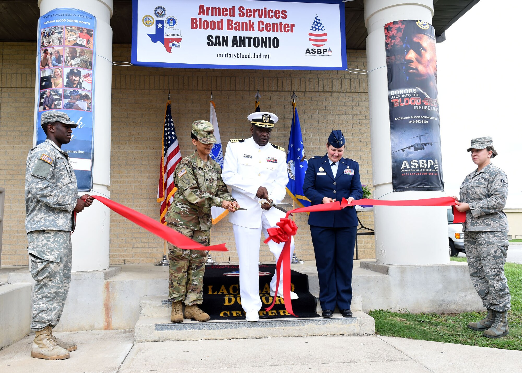 Navy Capt. Roland Fahie (center) cuts the ribbon to the Armed Services Blood Bank Center San Antonio during a recent ceremony. The blood bank, led by the 59th Medical Wing, is a tri-service venture involving the Army, Navy, and Air Force. Fahie is the Department of Defense Director of the Armed Services Blood Program. (U.S. Air Force photo/Tech. Sgt. Christopher Carwile)