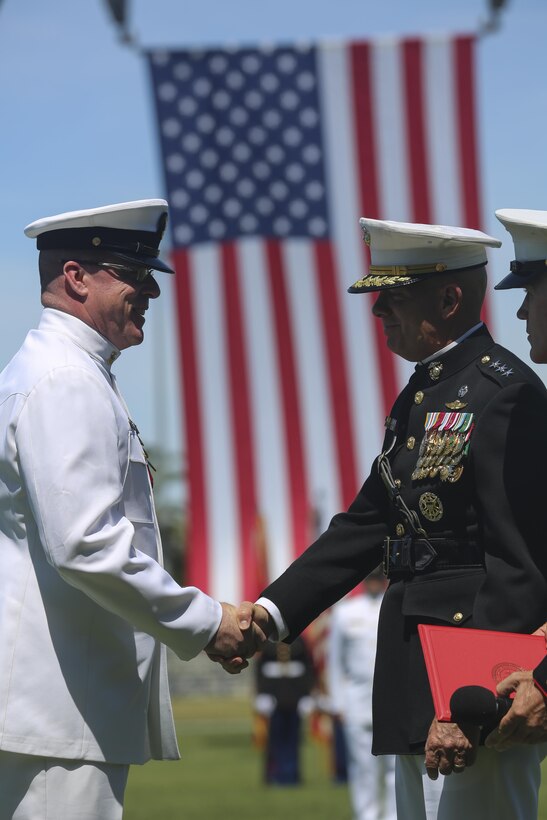 MARINE CORPS BASE CAMP PENDLETON, Calif. - Master Chief Petty Officer Michael Smith, outgoing command master chief of I Marine Expeditionary Force, shakes the hand of Lt. Gen. David H. Berger, commanding general of I MEF, after being awarded the Legion of Merit during his change of charge and retirement ceremony on Camp Pendleton June 3, 2016. Replacing Smith as I MEF CMC is Master Chief Petty Officer Frank Dominguez, a Superior, Arizona native, who served with Smith, a Ridgecrest native, during Operation Iraqi Freedom I and II. (U.S. Marine Corps Photo By Cpl. Garrett White/Released)
