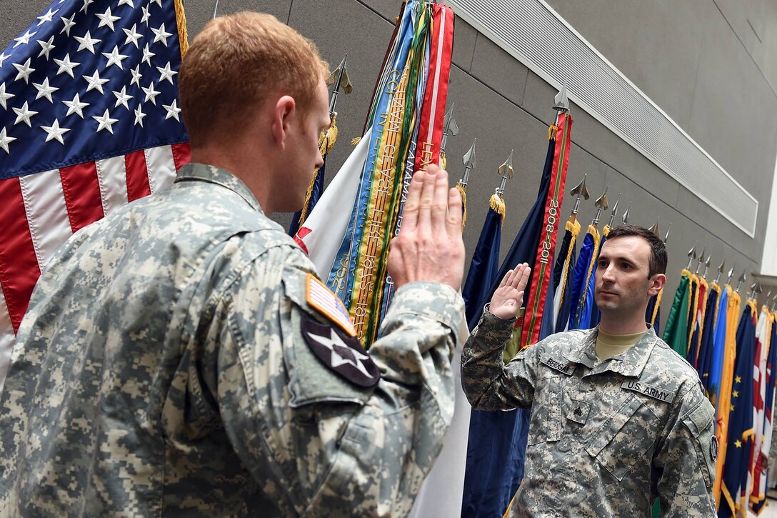 Sgt. Aaron Berogan, Public Affairs Specialist, 85th Support Command, recites the oath of enlistment during a reenlistment ceremony held at the command headquarters, June 4th, 2016.
(Photo by Sgt. 1st Class Anthony L. Taylor)