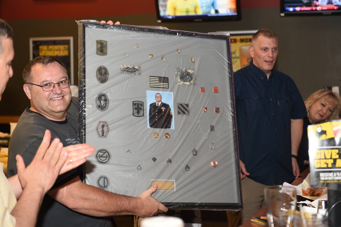 Sgt. 1st Class Stephen Harris, operations sergeant at the 85th Support Command, pauses with a plaque awarded to him during his farewell reception on June 4, 2016. Harris is scheduled to retire this summer.
(Photo by Spc. David Lietz)