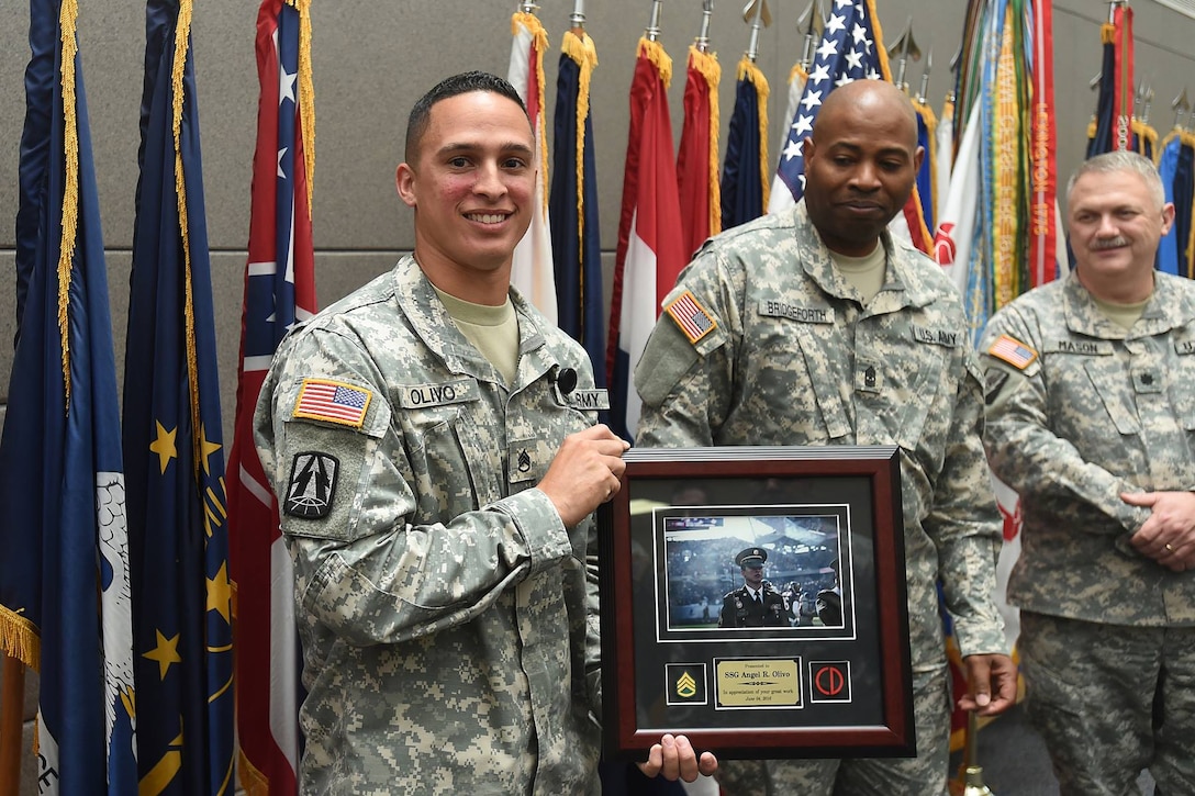 Staff Sgt. Angel Olivo, Information Technology Sergeant, 85th Support Command, pauses for a photo with Sgt. Maj. Steven Bridgeforth following a plaque presentation to him, June 5th, 2016, during the 85th Support Commands June battle assembly. Olivo will PCS to his next duty location within the next several weeks. 
(Photo by Spc. David Lietz)