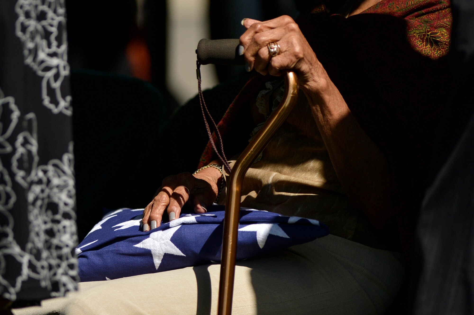 Nola Whitfield embraces her husband’s flag during the graveside ceremony honoring former 2nd Lt. Malvin G. Whitfield, an Army Air Forces and Air Force veteran, at Arlington National Cemetery, Va., June 8, 2016. Whitfield later served as a youth and sports affairs officer for the U.S. Information Agency where he traveled to more than 132 countries and played a key role in training and developing African athletes. (U.S. Air Force photo/Tech. Sgt. Joshua L. DeMotts)