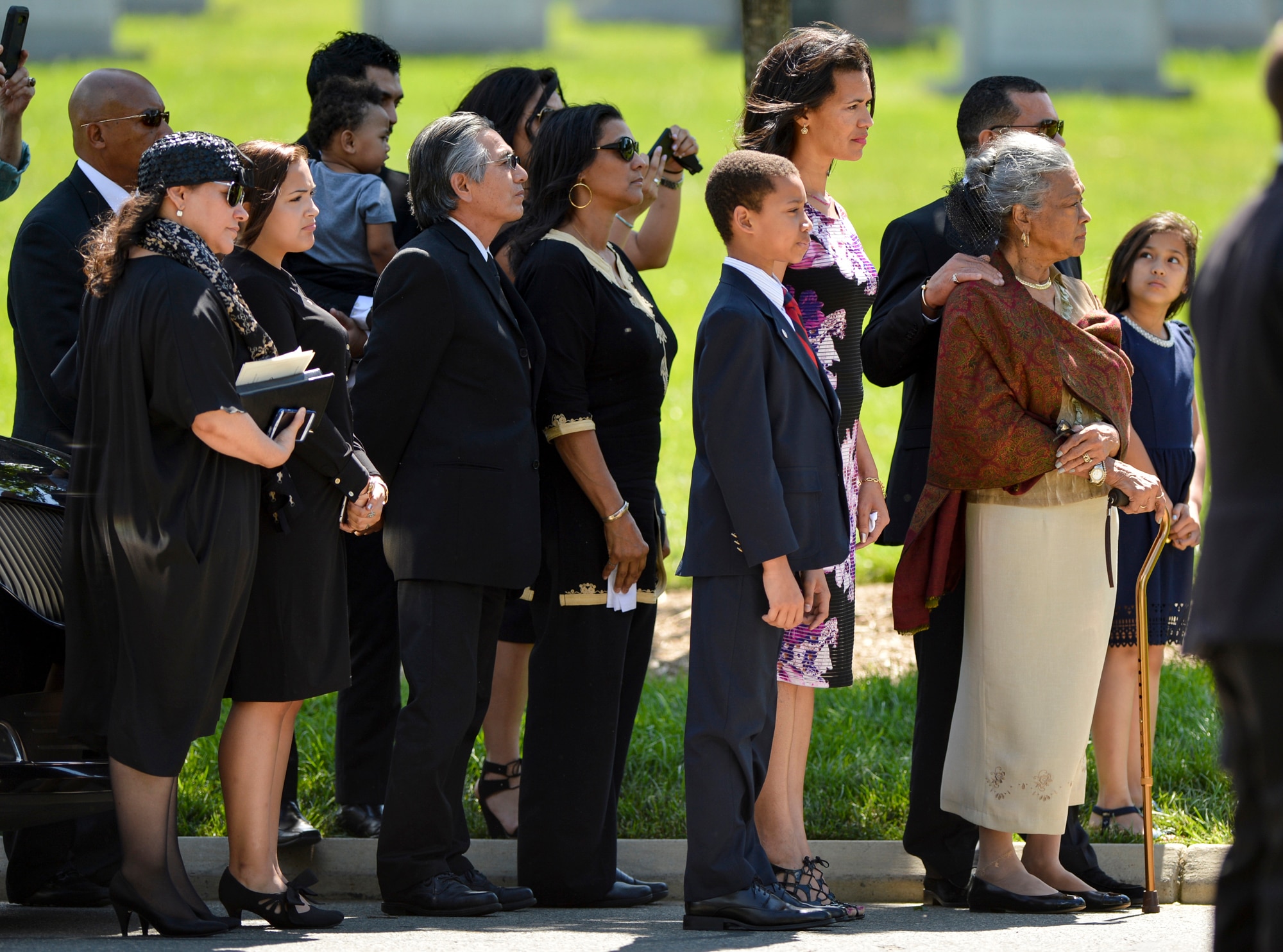 The family of former 2nd Lt. Malvin G. Whitfield watch as Whitfield's casket arrives at his burial site in Arlington National Cemetery in Arlington, Va., on June 8, 2016. While serving in the Korean War, Whitfield prepared to compete in track and field events at the 1951 Pan American Games by training on the runways between bombing missions.  (U.S. Air Force photo/Tech. Sgt. Joshua L. DeMotts)