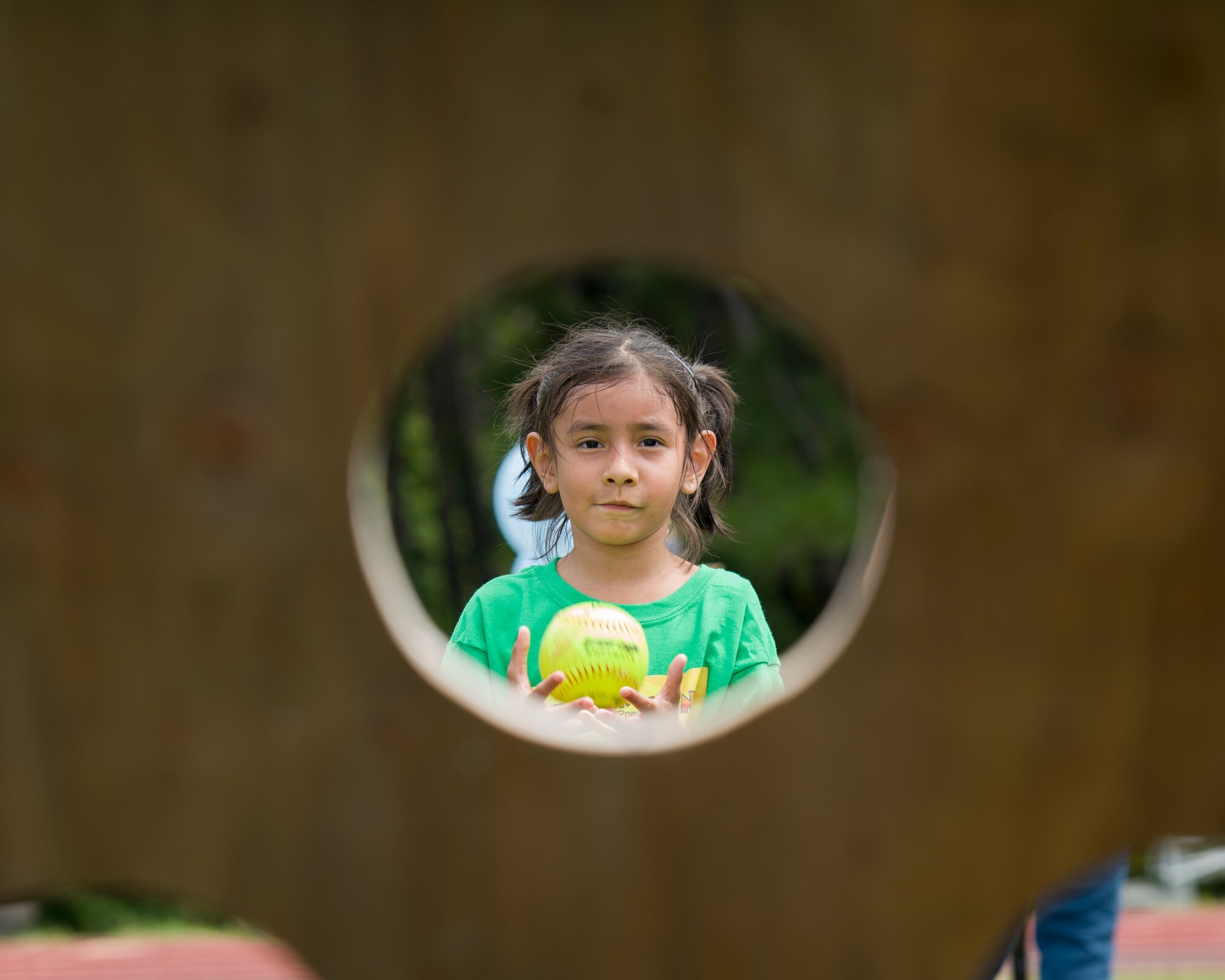 A child practices her aim with a softball during the Summer Reading Program opening ceremonies at Hurlburt Field, Fla., June 9, 2016. The program opened with a summer Olympics-themed event where Hurlburt youth participated in 10 activity stations. The stations combined mental and physical challenges to teach children about the importance of mental and physical training. (U.S. Air Force photo by Airman 1st Class Kai White)