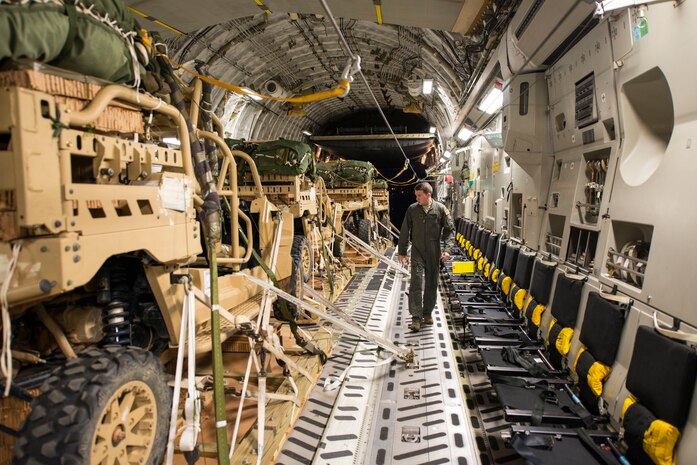 Senior Airman Nick Church, 437th Airlift Wing loadmaster, inspects cargo prior to take off June 6, 2016. The cargo was dropped as part of Exercise Swift Response. In addition to participating in Exercise Swift Response, AMC air crews completed the first operational drop of expendable platforms. In the past, heavy cargo was dropped using metal heavy equipment platforms which needed to be recovered. The expendable platforms allow the paratroopers, once on the ground, to detach the vehicles from the platform quickly without having to worry about recovering the platform. (U.S. Air Force photo/Staff Sgt. William A. O'Brien)