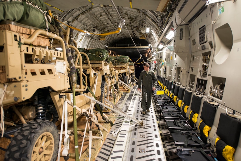 Senior Airman Nick Church, 437th Airlift Wing loadmaster, inspects cargo prior to take off June 6, 2016. The cargo was dropped as part of Exercise Swift Response. In addition to participating in Exercise Swift Response, AMC air crews completed the first operational drop of expendable platforms. In the past, heavy cargo was dropped using metal heavy equipment platforms which needed to be recovered. The expendable platforms allow the paratroopers, once on the ground, to detach the vehicles from the platform quickly without having to worry about recovering the platform. (U.S. Air Force photo/Staff Sgt. William A. O'Brien)