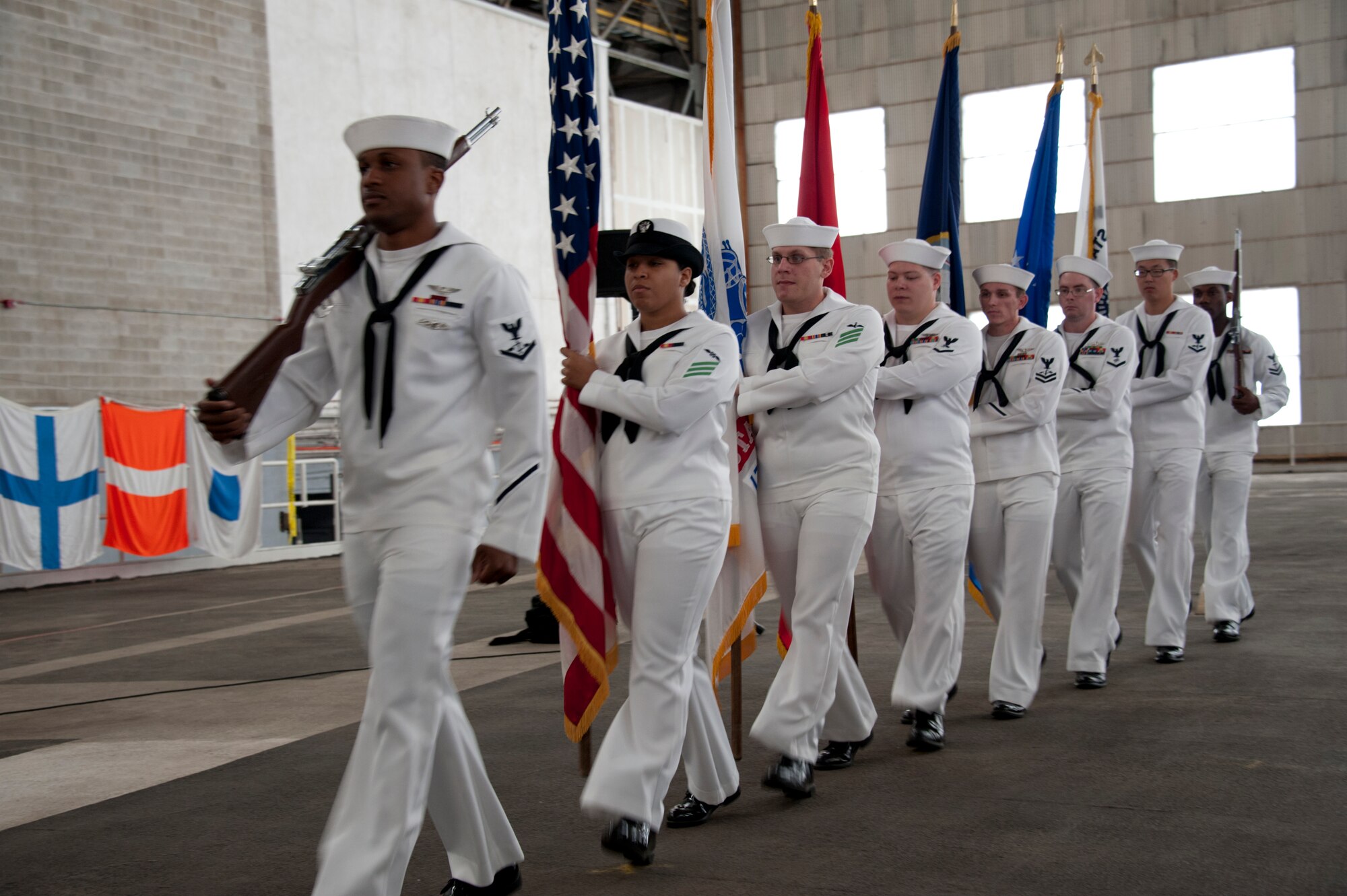 Sailors from the Naval Support Activity Lakehurst Honor Guard march for the posting of the colors aboard the flight deck in Hangar 1 during the 74th Commemoration ceremony of the Battle of Midway. (U.S. Air Force photo by Pascual Flores/Released)