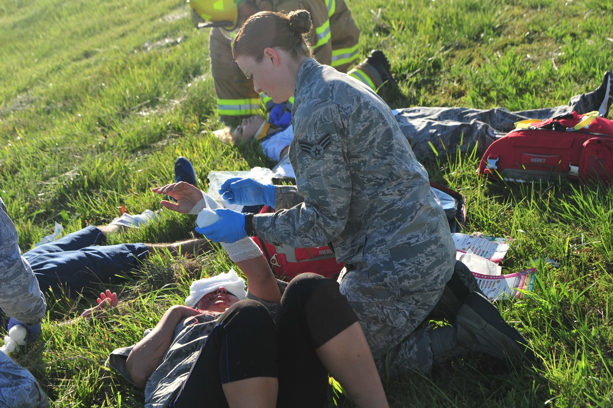 U.S. Air Force Senior Airman Katelyn Potts, an aerospacial medical technician assigned to the 509th Medical Operations Squadron, applies medical aid to a simulated aircraft accident victim during a major accident response exercise (MARE) at Whiteman Air Force Base, Mo., June 8, 2016. Firefighters and other emergency response personnel conducted the MARE to prepare for any mishaps that may occur in real-world situations.  (US Air Force photo by Senior Airman Jovan Banks)