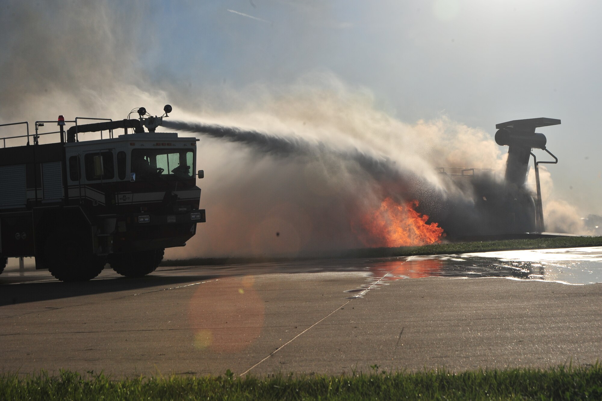 Firefighters from the 509th Civil Engineer Squadron move their fire engine into position to extinguish a simulated aircraft fire during a major accident response exercise (MARE) at Whiteman Air Force Base, Mo., June 8, 2016. Firefighters and other emergency response personnel conducted the MARE to prepare for any mishaps that may occur in real-world situations. (US Air Force photo by Senior Airman Jovan Banks)