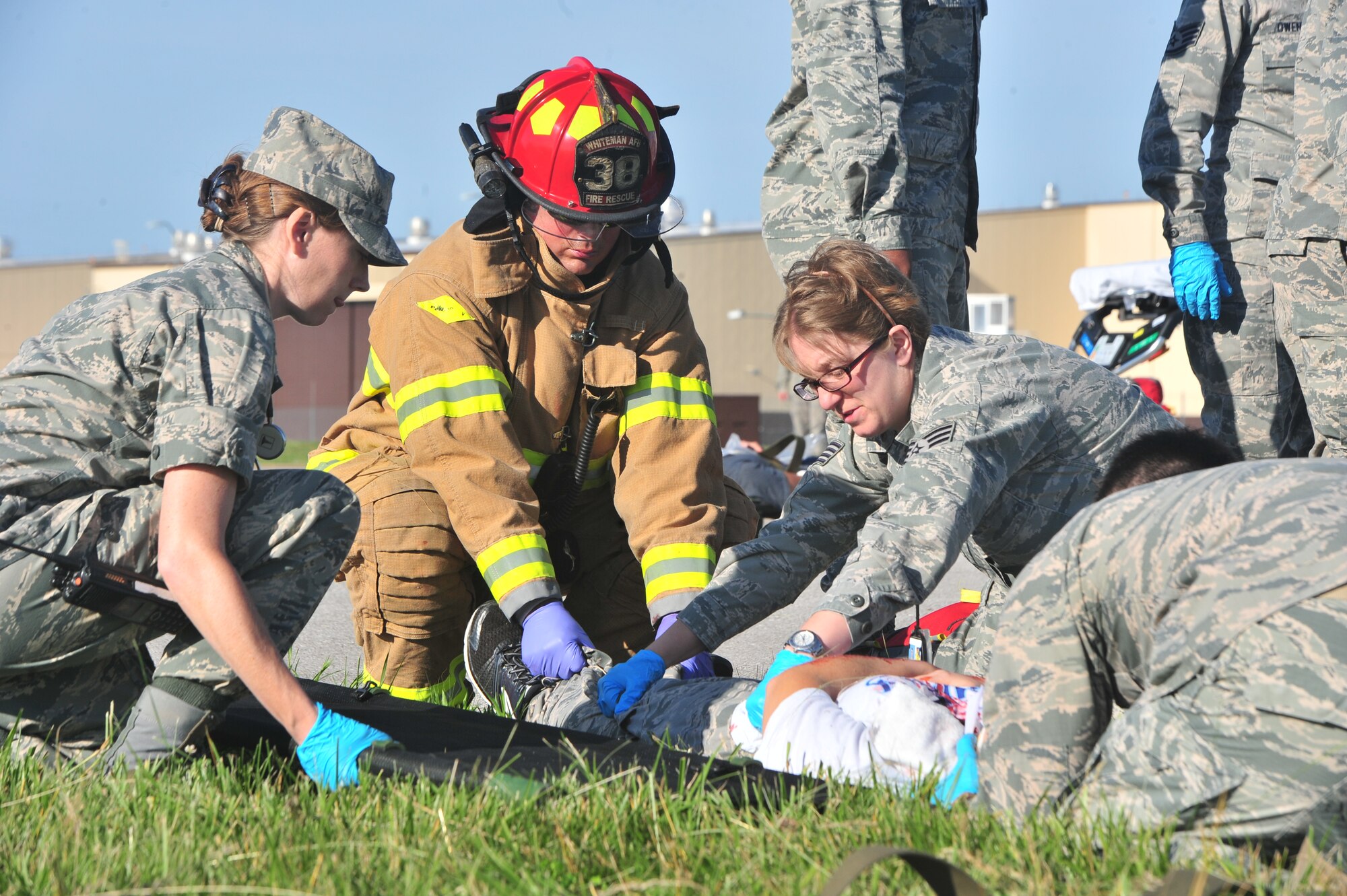 Members of Team Whiteman work together to aid a simulated aircraft accident victim during a major accident response exercise (MARE), at Whiteman Air Force Base, Mo., June 8, 2016. During a MARE all simulated medical injuries and victims are treated as real by firefighters and medical Airmen adding the importance of urgency to the training. 
(US Air Force photo by Senior Airman Jovan Banks)
