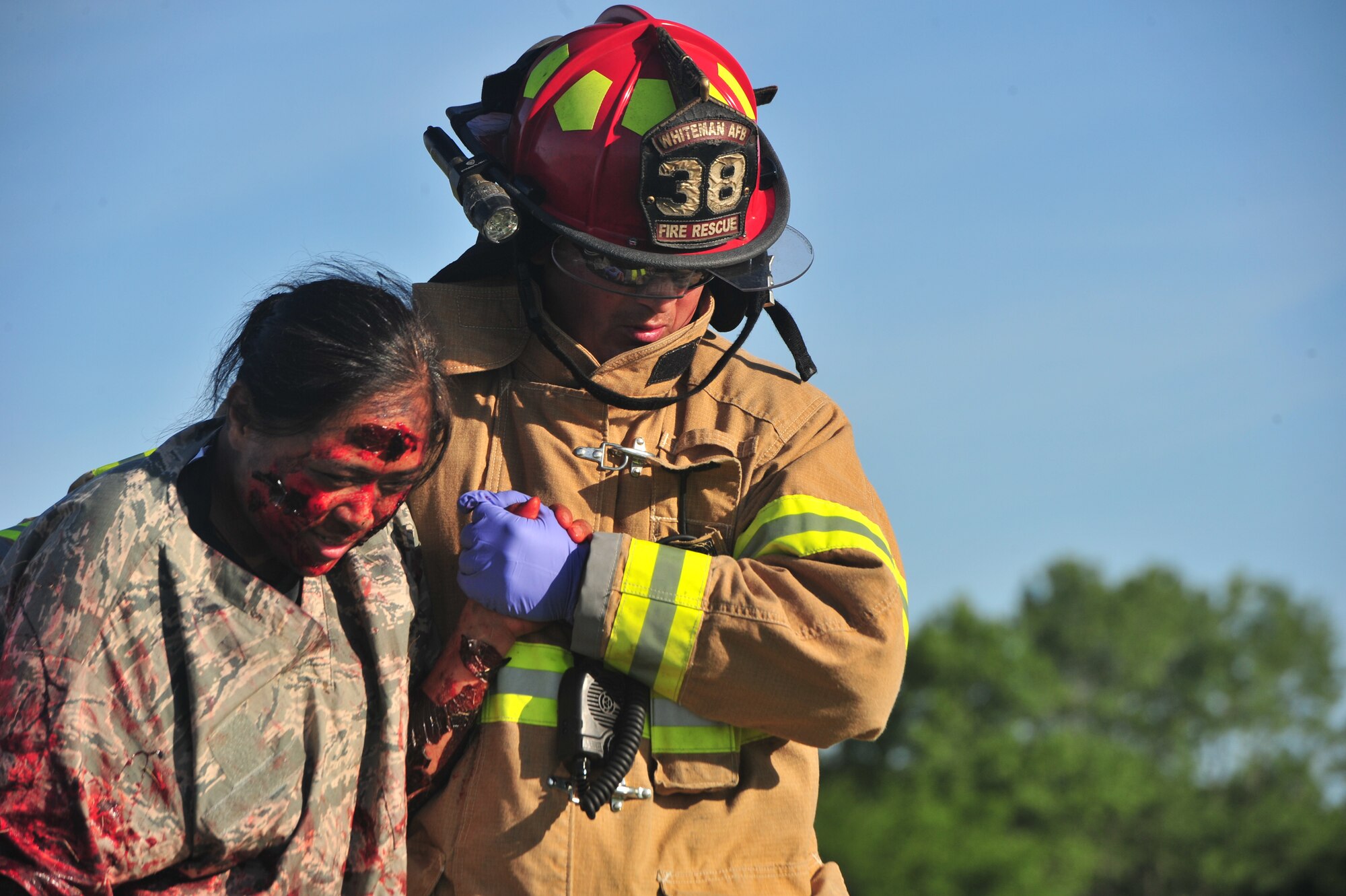A firefighter from the 509th Civil Engineer Squadron escorts a simulated wounded Airman from a simulated crash site during a major accident response exercise (MARE)at Whiteman Air Force Base, Mo., June 8, 2016. During a MARE all simulated medical injuries and victims are treated as real by firefighters and medical Airmen adding the importance of urgency to the training. 
(US Air Force photo by Senior Airman Jovan Banks)
