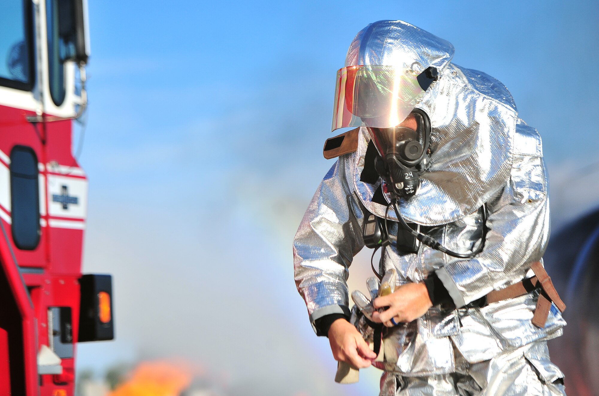A firefighter from the 509th Civil Engineer Squadron makes adjustments to his gear prior to engaging with a simulated aircraft fire during a major accident response exercise (MARE) at Whiteman Air Force Base, Mo., June 8, 2016. The exercise is conducted to test readiness and response times in case of a major accident.  (US Air Force photo by Senior Airman Jovan Banks)