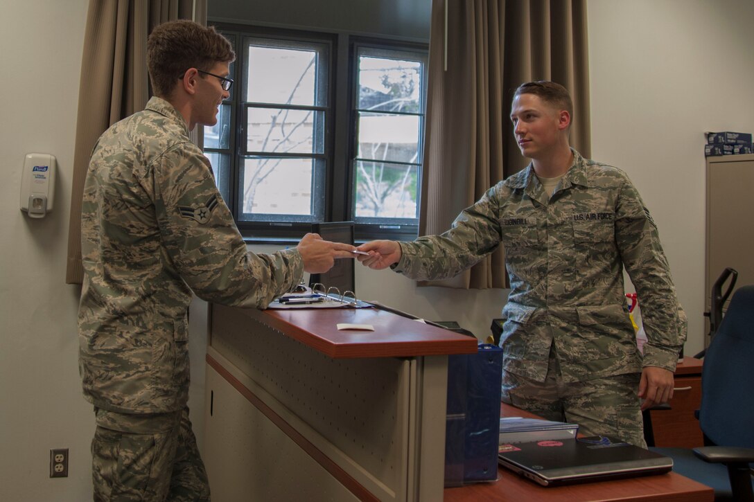 Staff Sgt. Cody Luginbill, 11th Civil Engineer Squadron Airman dorm leader, takes a defective room key from Airman 1st Class Marco Pena, 779th Dental Squadron biomedical technician, at Joint Base Andrews, Md., June 3, 2016. As part of dorm management Luginbill fulfills the various maintenance requests residents report. (U.S. Air Force photo by Airman 1st Class Rustie Kramer/Released)