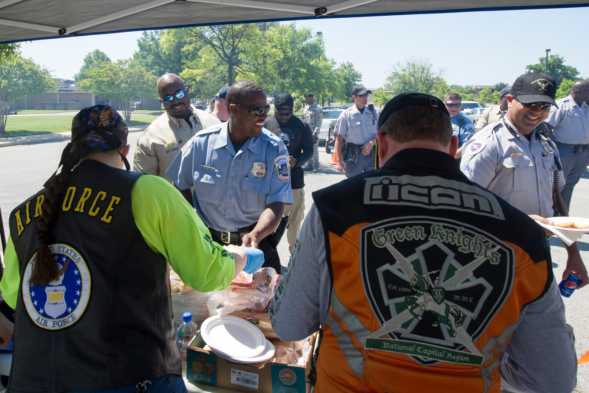 Members of the Green Knights’ Motorcycle Club hand out food to local authorities during Motorcycle Safety Day on Joint Base Andrews, Md., June 9, 2016. The day included vendors, local clubs, food, demonstrations, riding groups and prize giveaways. (U.S. Air Force photo by Senior Airman Ryan J. Sonnier/RELEASED)