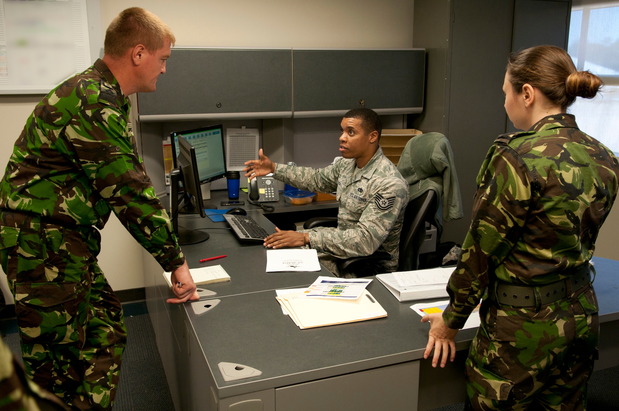 U.S. Air Force Tech. Sgt. Rendell Smith, senior maintenance production controller with the 187th Maintenance Group, talks with Romanian air force Maj. Constantin Pecete and 2nd Lt. Chirila Sandu June 8, 2016, at the Montgomery Regional ANGB, Ala. Romanian air force maintainers visited the 187th to share information and strengthen their partnership. (A portion of this image was masked for security purposes. U.S. Air National Guard photo by Staff Sgt. Jared Rand/Released)