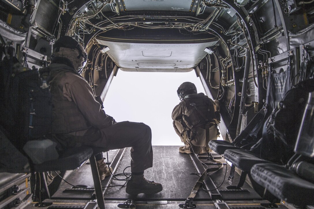 Two Marines observe the area outside an MV-22B Osprey during a flight from Marine Corps Air Station Miramar to Marine Corps Base Camp Pendleton, Calif., June 8, 2016. Marine Corps photo by Sgt. Michael Thorn