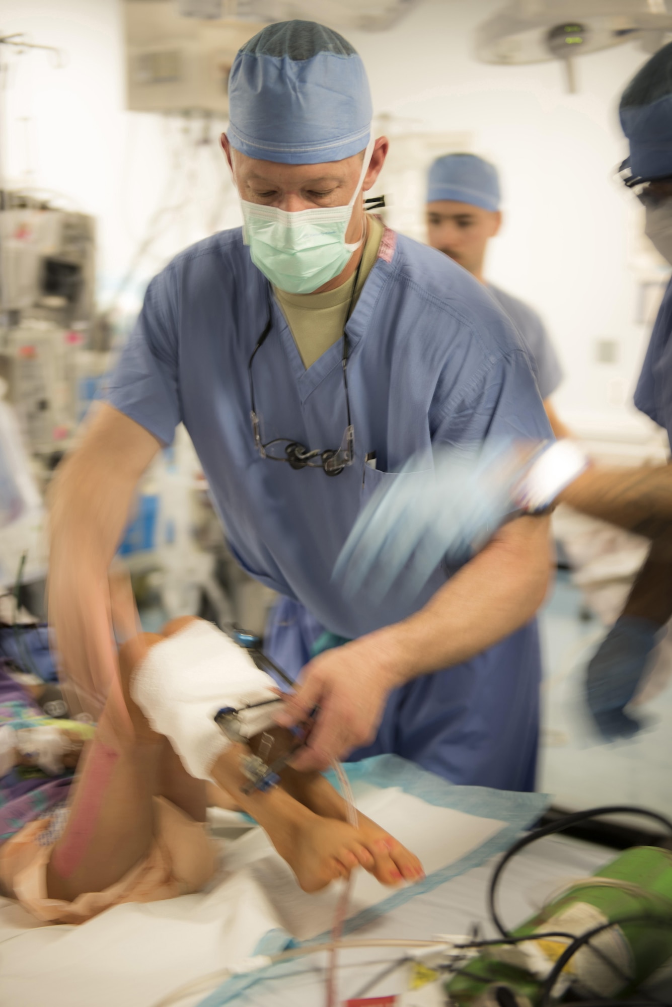 Lt. Col Chance Henderson, 455th Expeditionary Medical Group orthopedic surgeon, wraps gauze around the patients legs after surgery, June 10, 2016, at Craig-Joint Theater Hospital, Bagram Airfield, Afghanistan. Lt. Col. Henderson has performed multiple surgeries on the patient in an effort to save her leg from amputation. The patient was brought to the hospital after suffering from a gun-shot wound. (U.S. Air Force photo by Tech. Sgt. Tyrona Lawson)