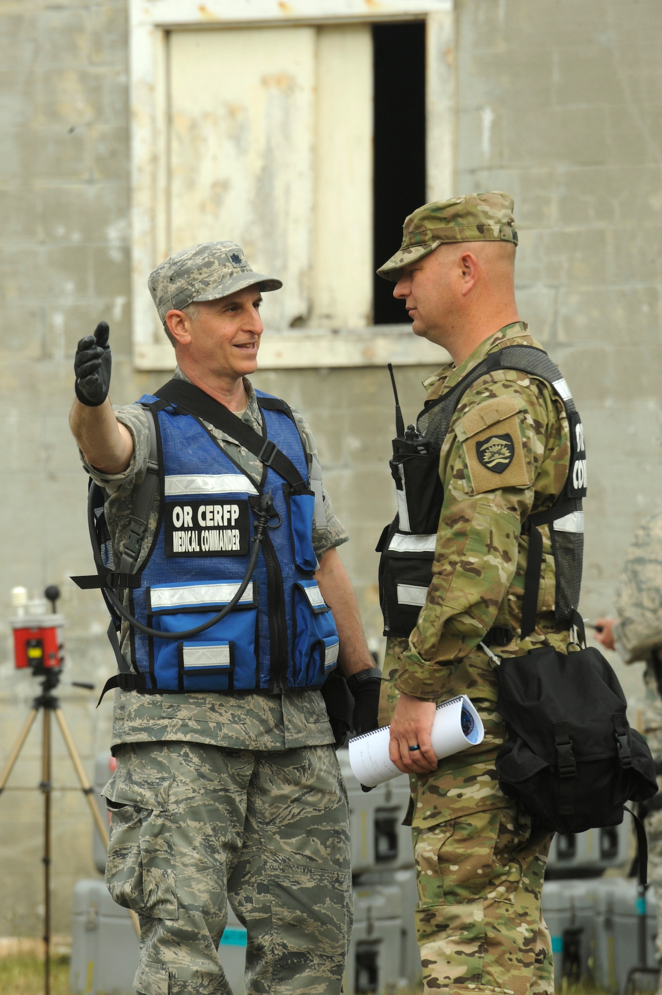 Oregon Air National Guard Lt. Col. Alex Charney-Cohen, left, and Oregon Army National Guard Lt. Col. Michael Moffit, CERFP commander, right, confers the set up area for equipment and materials in the exercise village at Camp Rilea during Cascadia Rising exercise, Warrenton, Ore., June 9, 2016. Cascadia Rising scenario is a 9.0 magnitude earthquake along the Cascadia Subduction Zone (CSZ) resulting in a tsunami, testing first responders, emergency management and public safety officials in the Pacific Northwest. (U.S. Air National Guard photo by Tech. Sgt. John Hughel, 142nd Fighter Wing Public Affairs/Released) 