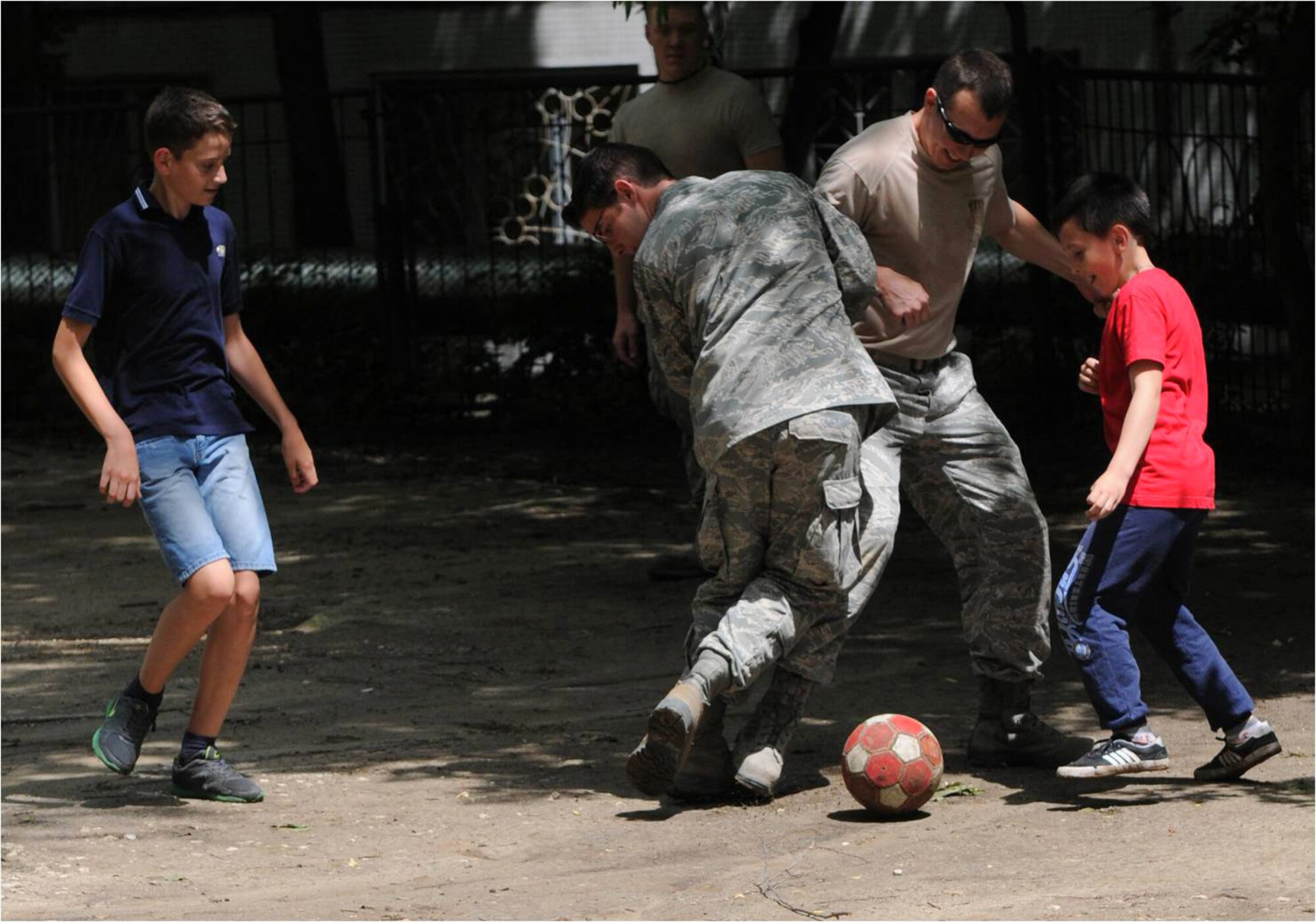 Airmen from the Kentucky Air National Guard’s 123rd Civil Engineer Squadron in Louisville, Kentucky, play soccer with children outside Special School #12 in Chisinau, Moldova, June 4, 2016. More than 35 Airmen from the unit are renovating the institution, which is the only school in Moldova specifically for deaf and special-needs students. The humanitarian project is a partnership with the Office of Defense Cooperation and U.S. European Command, with funds being provided by the National Guard Bureau. (U.S. Air National Guard photo by Tech. Sgt. Vicky Spesard)