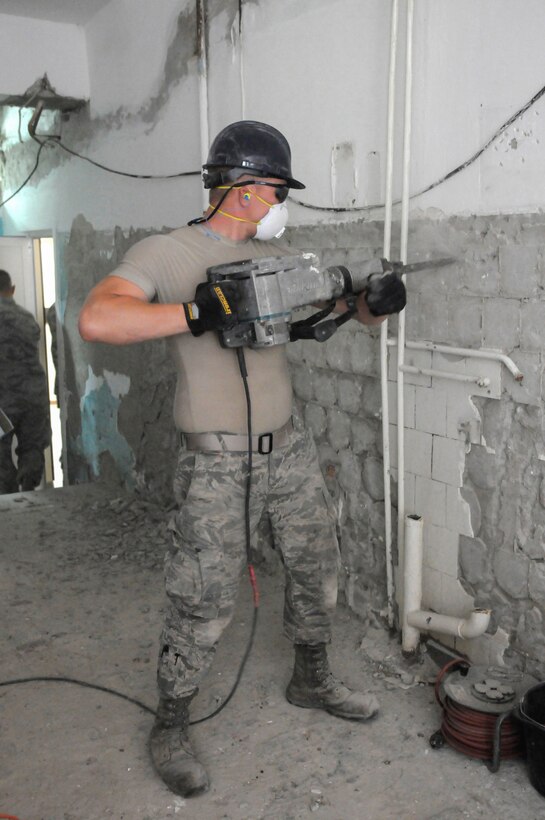 U.S. Air Force Airman First Class Joey Wurzelbacher from the Kentucky Air National Guard’s 123rd Civil Engineer Squadron in Louisville, Kentucky, removes old brick and tile work from the kitchen wall of Special School #12 in Chisinau, Moldova, June 4, 2016. More than 35 Airmen from the unit are renovating the institution, which is the only school in Moldova specifically for deaf and special-needs students. The humanitarian project is a partnership with the Office of Defense Cooperation and U.S. European Command, with funds being provided by the National Guard Bureau. (U.S. Air National Guard photo by Tech. Sgt. Vicky Spesard)