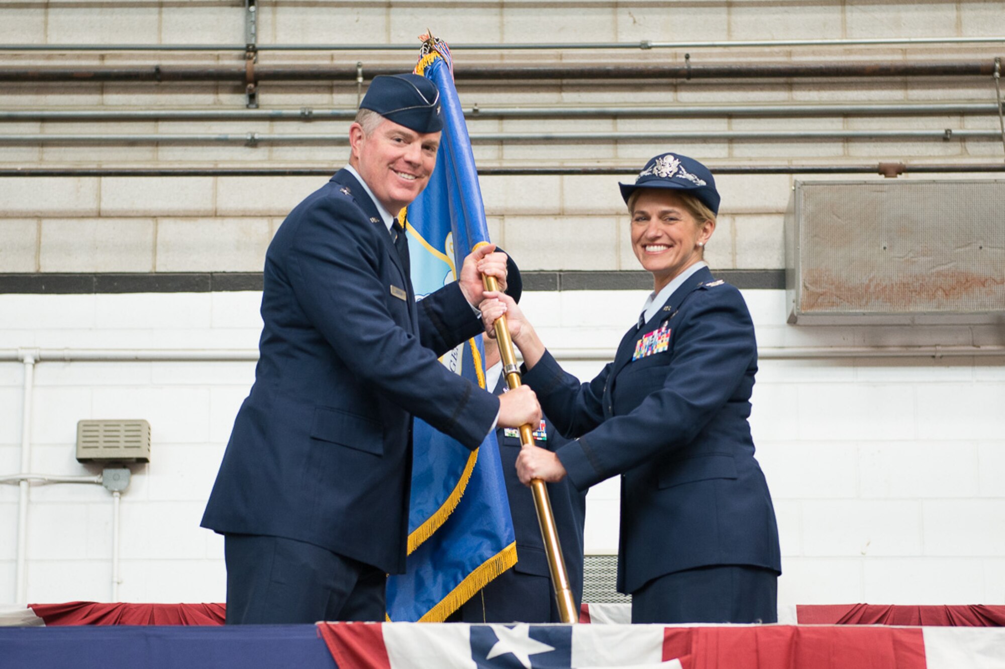 Col. Virginia I. Doonan accepts the 102nd Intelligence Wing guidon from Brig. Gen. Robert T. Brooks Jr., Commander, Massachusetts Air National Guard. Doonan became the commander of the 102nd Intelligence Wing on Friday, succeeding Brig. Gen. James M. LeFavor, who had served as commander since Nov. 2013. (U.S. Air National Guard photo by Tech. Sgt. Kerri Spero/Released)