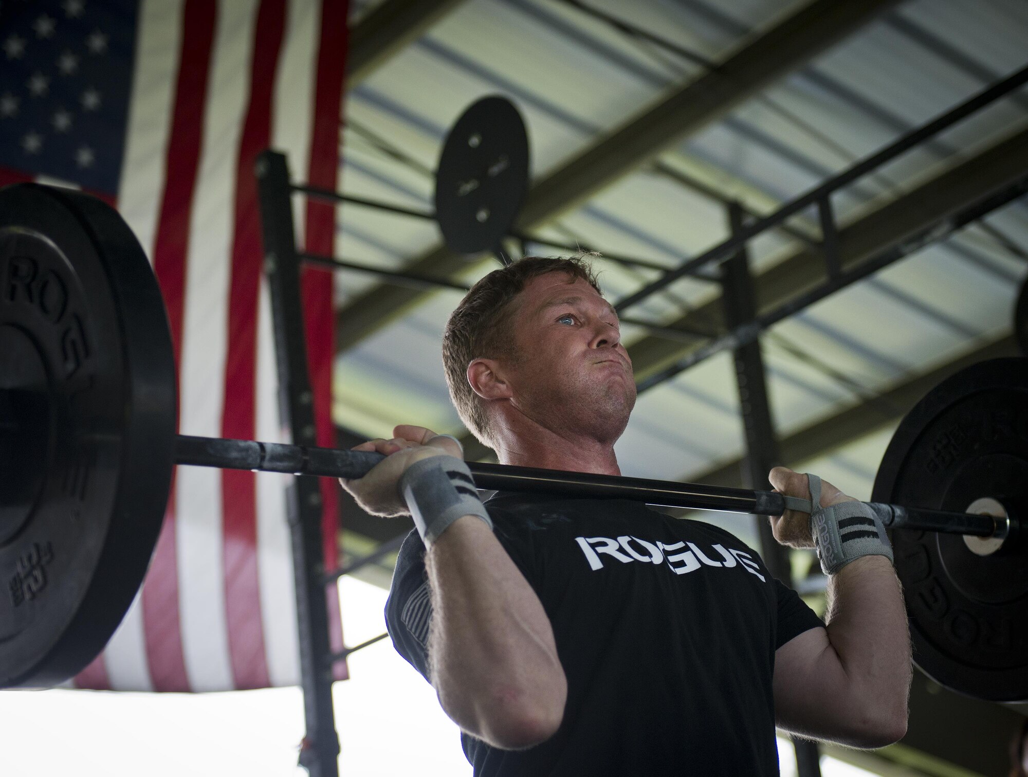 Devin Widdoes, 7th Special Forces Group, prepares to lift weights over his head during a team combat fit competition June 11 at Duke Field, Fla.  The three-round competition pushed the teams to their limits with repetitive weight lifting, rowing, sled-pulling and other kinetic activities.  (U.S. Air Force photo/Tech. Sgt. Sam King)