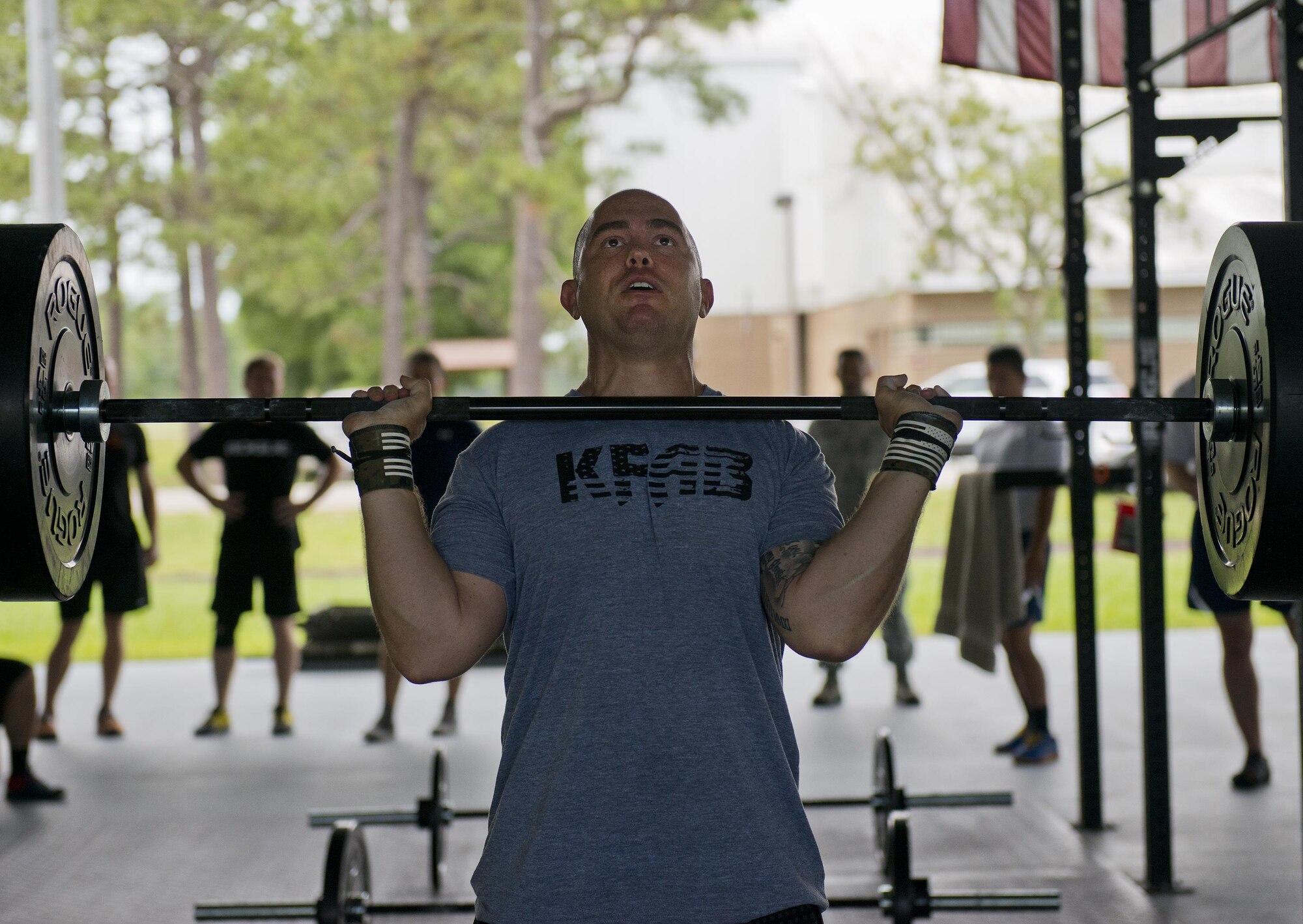 Tech. Sgt. Andrew Knudsen, 919th Special Operations Maintenance Group, prepares to lift weights over his head during a team combat fit competition June 11 at Duke Field, Fla.  The three-round competition pushed the teams to their limits with repetitive weight lifting, rowing, sled-pulling and other kinetic activities.  (U.S. Air Force photo/Tech. Sgt. Sam King)