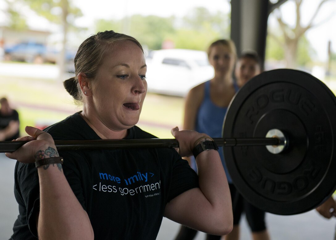 Selena Shaw prepares to lift weights over her head during a team combat fit competition June 11 at Duke Field, Fla.  The three-round competition pushed the teams to their limits with repetitive weight lifting, rowing, sled-pulling and other kinetic activities.  (U.S. Air Force photo/Tech. Sgt. Sam King)