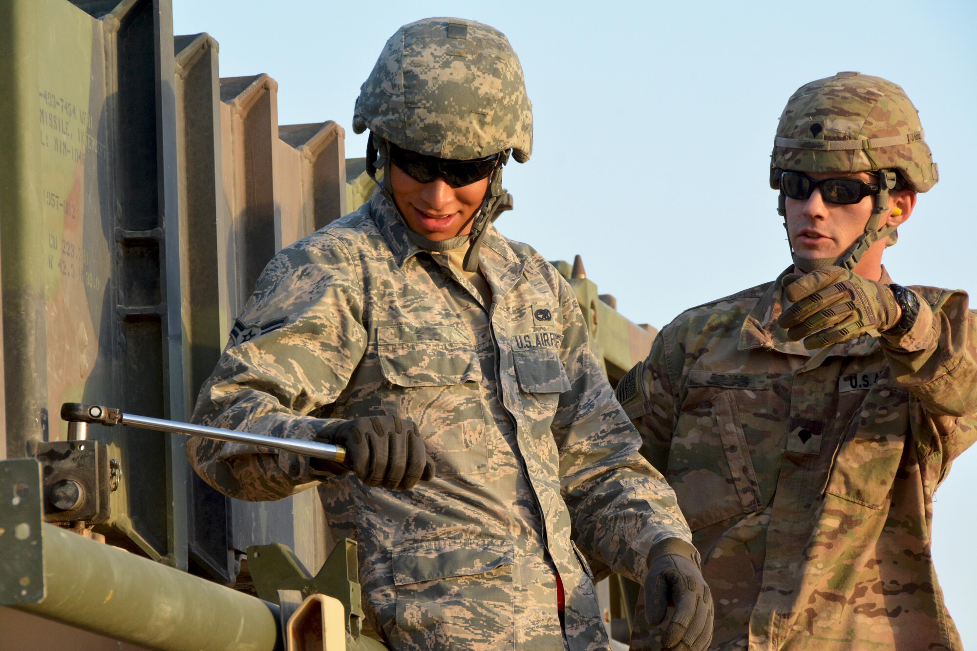 Spc. Collin, Army 3rd Battalion 2nd Air Defense Artillery Regiment Charlie Battery missile technician, guides Airman 1st Class Brandon, 380th Expeditionary Aircraft Maintenance Squadron munitions load crewmember, during a Patriot training missile load, June 4. The Army regiment hosted an information exchange with the 380th Air Expeditionary Wing in an effort to arm Soldiers and Airmen with a better understanding of ground and aerial aspects of air superiority. (U.S. Air Force photo by Staff Sgt. Samantha Mathison)