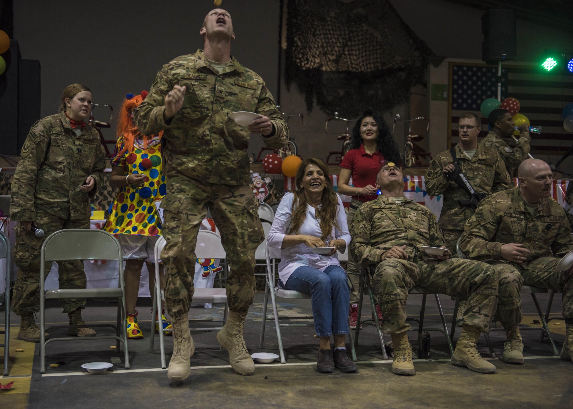 Brig. Gen. James Sears, 455th Air Expeditionary Wing commander, tosses a cookie into the air during a carnival block party game hosted by the 455th Expeditionary Force Support Squadron, at Bagram Airfield, Afghanistan, June 11, 2016. The 455th EFSS hosts these events so servicemembers can relieve stress and help them cope with being away from their loved ones. (U.S. Air Force photo by Senior Airman Justyn M. Freeman)