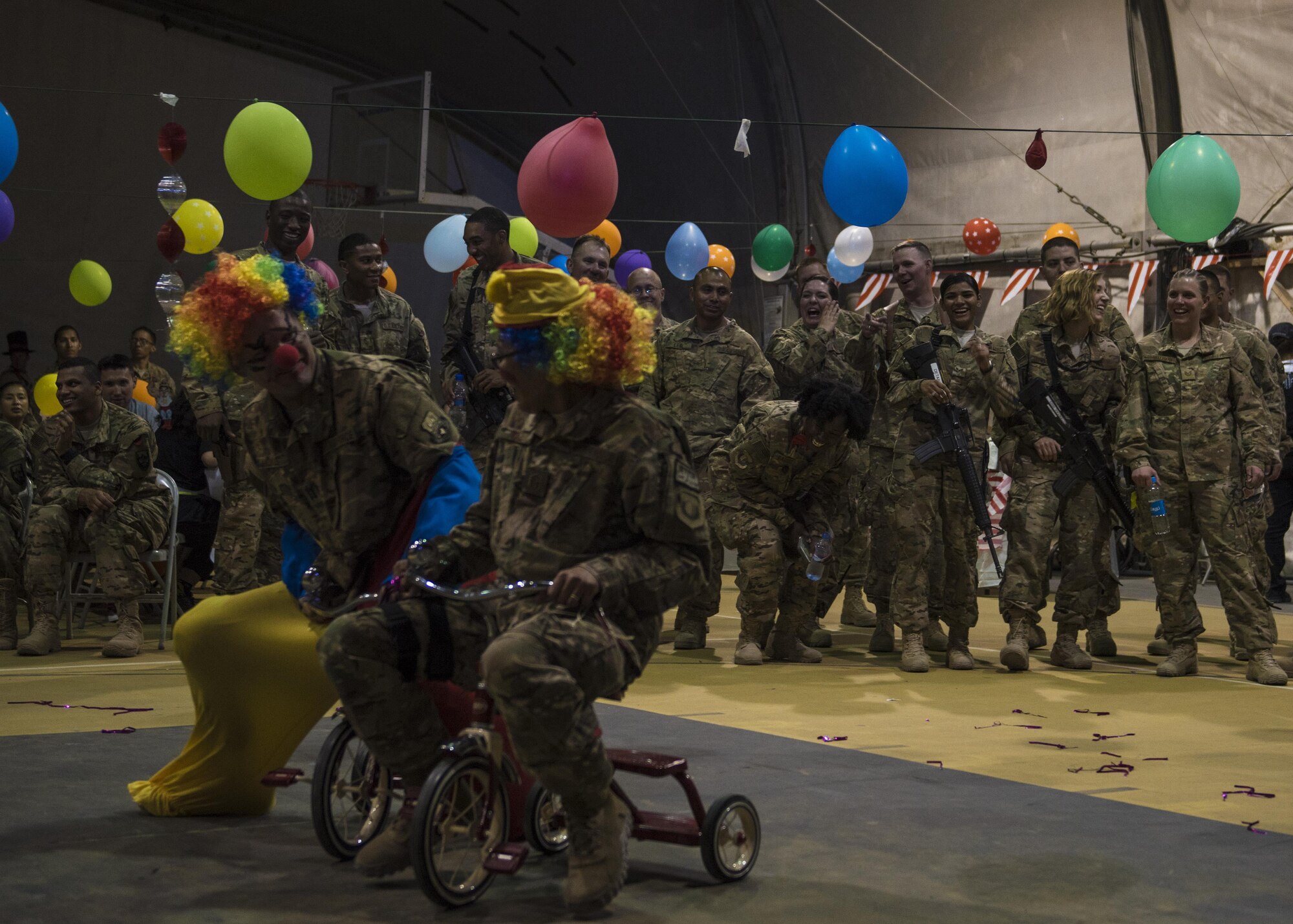 Servicemembers laugh at the clown race during the carnival block party hosted by the 455th Expeditionary Force Support Squadron, at Bagram Airfield, Afghanistan, June 11, 2016. The 455th EFSS host the block parties monthly to bring together coalition forces in a fun, inviting, and friendly environment. (U.S. Air Force photo by Senior Airman Justyn M. Freeman)