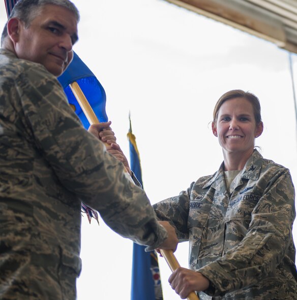 Col. Regina Sabric accepts the guidon from Col. James Phillips, the 919th Special Operations Wing commander, at the 919th Special Operations Group’s change of command ceremony June 12 at Duke Field, Fla.  Sabric was stationed at the Pentagon before becoming the first female commander of the group.  (U.S. Air Force photo/Tech. Sgt. Sam King)