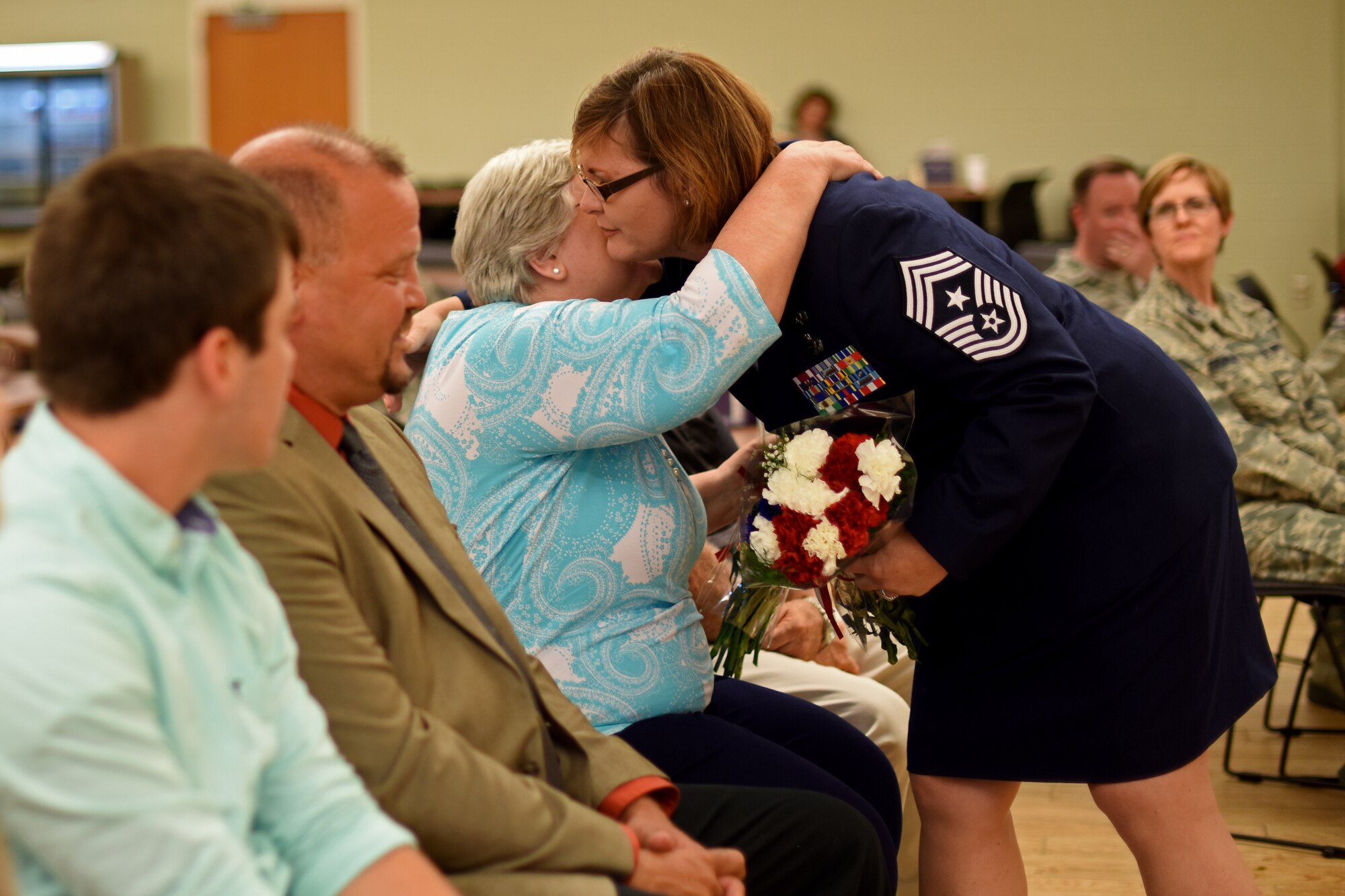 U.S. Air Force Chief Master Sgt. Kelly Gibbs, 121st Air Refueling Wing command chief, hugs her mother during an assumption of command ceremony on June 11, 2016, Rickenbacker Air National Guard Base, Ohio. As the unit's newest command chief, Chief Master Sgt. Gibbs is responsible for advising the commander on matters of mission effectiveness; readiness; training and the health, morale and welfare of all 121 ARW enlisted members. (U.S. Air National Guard photo by Senior Airman Wendy Kuhn/Released)
