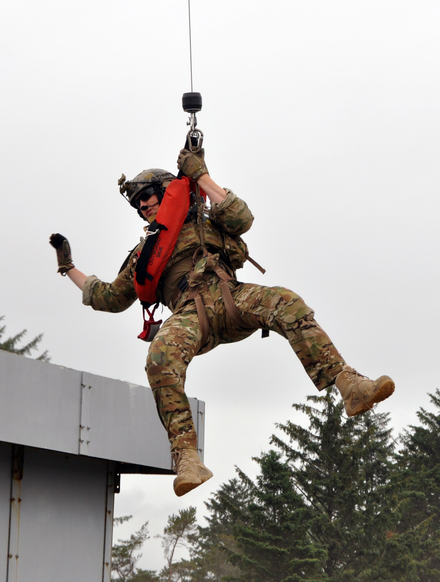 A pararescueman from the 304th Rescue Squadron, Portland Air National Guard Base, Ore., is lowered onto a rooftop from an HH-60G Pave Hawk helicopter from the 305th Rescue Squadron, Davis-Monthan Air Force Base, Ariz., June 8, 2016 at Camp Rilea, Ore., during a simulated urban rescue scenario. Several 304th personnel, plus Air and Army National Guardsmen and other local, state and federal government and civilian organizations participated in Cascadia Rising, a disaster response exercise simulating a magnitude 9.0 earthquake and subsequent tsunami in the Pacific Northwest. (U.S. Air Force photo by 1st Lt. Anna-Marie Wyant)