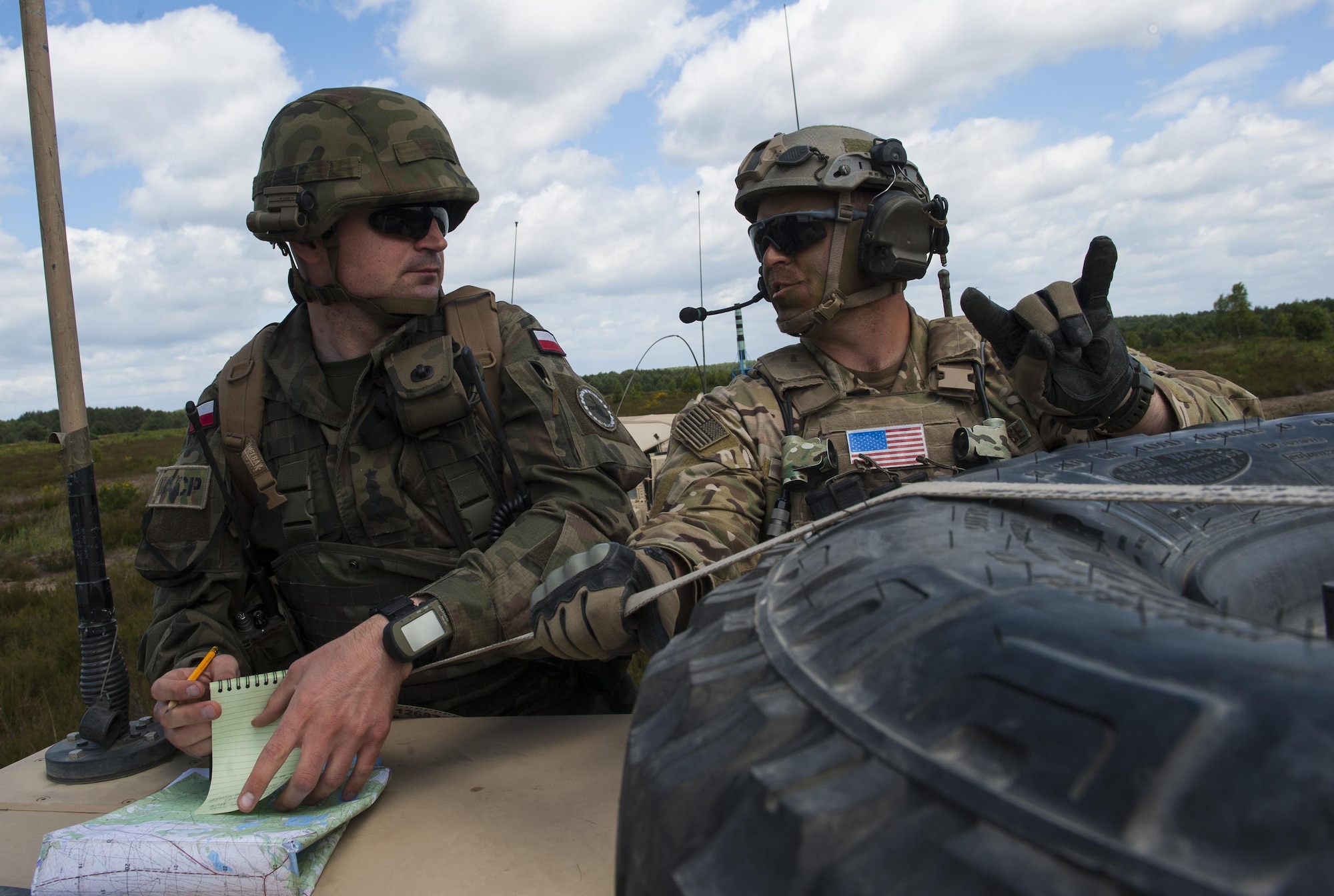 U.S. Air Force Tech. Sgt. Cody Quinn, 15th Air Space Operations Squadron training NCO in charge, helps a Polish joint terminal attack controller soldier as they coordinate a training event during Exercise Anakonda 2016 June 10, 2016, in Poland. Anakonda 2016 is a Polish national exercise that seeks to train, exercise and integrate Polish national command force structures into an environment involving other countries. This exercise further supports assurance and deterrence measures by demonstrating allied defense capabilities. (U.S. Air Force photo/Airman 1st Class Lane T. Plummer)