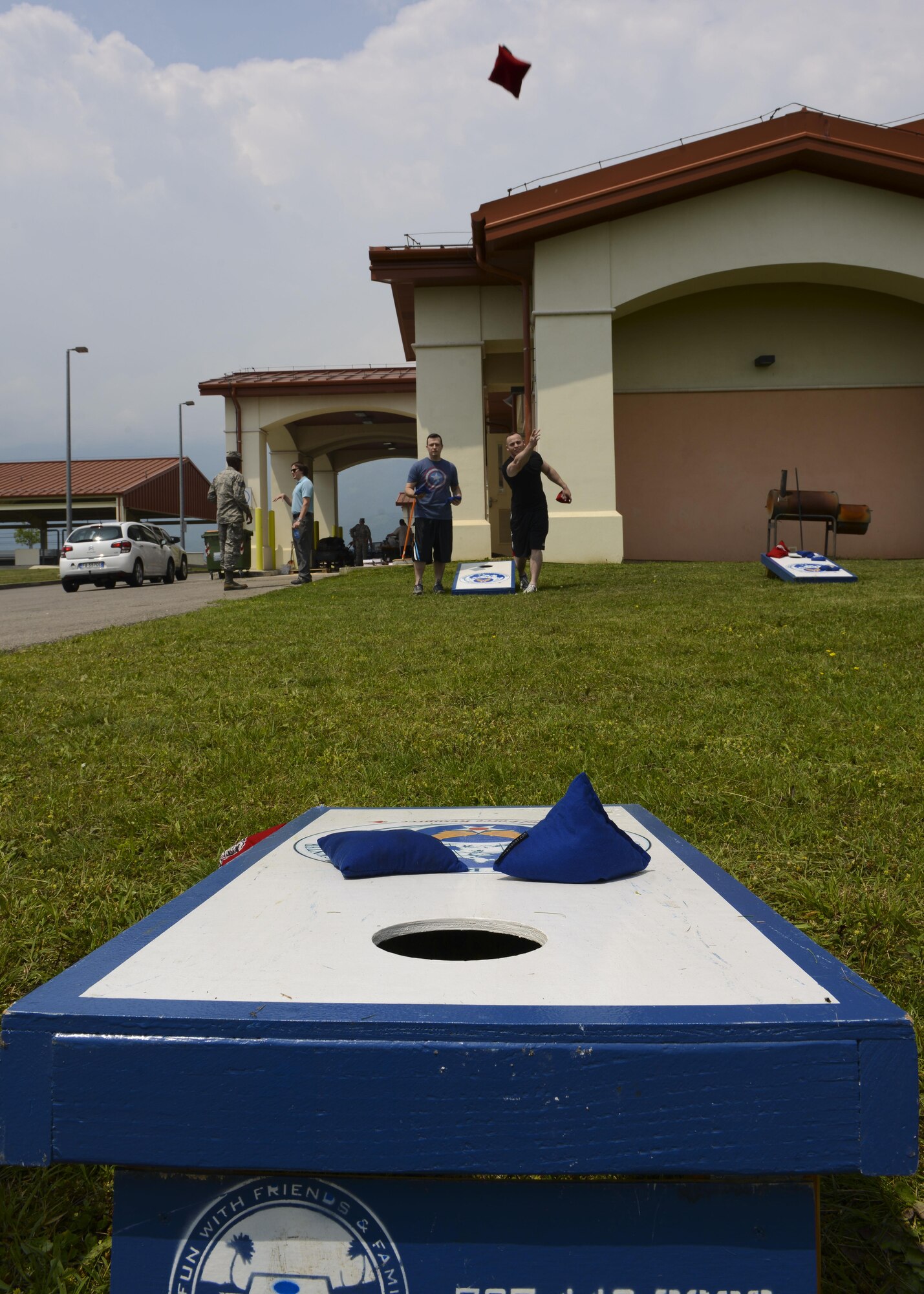 Tech. Sgt. David McCauley, 31st Maintenance Squadron quality assurance program manager, and Staff Sgt. Timothy Gensure, 31st MXS test measurement diagnostic equipment supervisor, play bean-bag toss during a wing picnic, June 9, 2016, at Aviano Air Base, Italy. Live entertainment and free food were also provided at the event. (U.S. Air Force photo by Senior Airman Austin Harvill/Released)