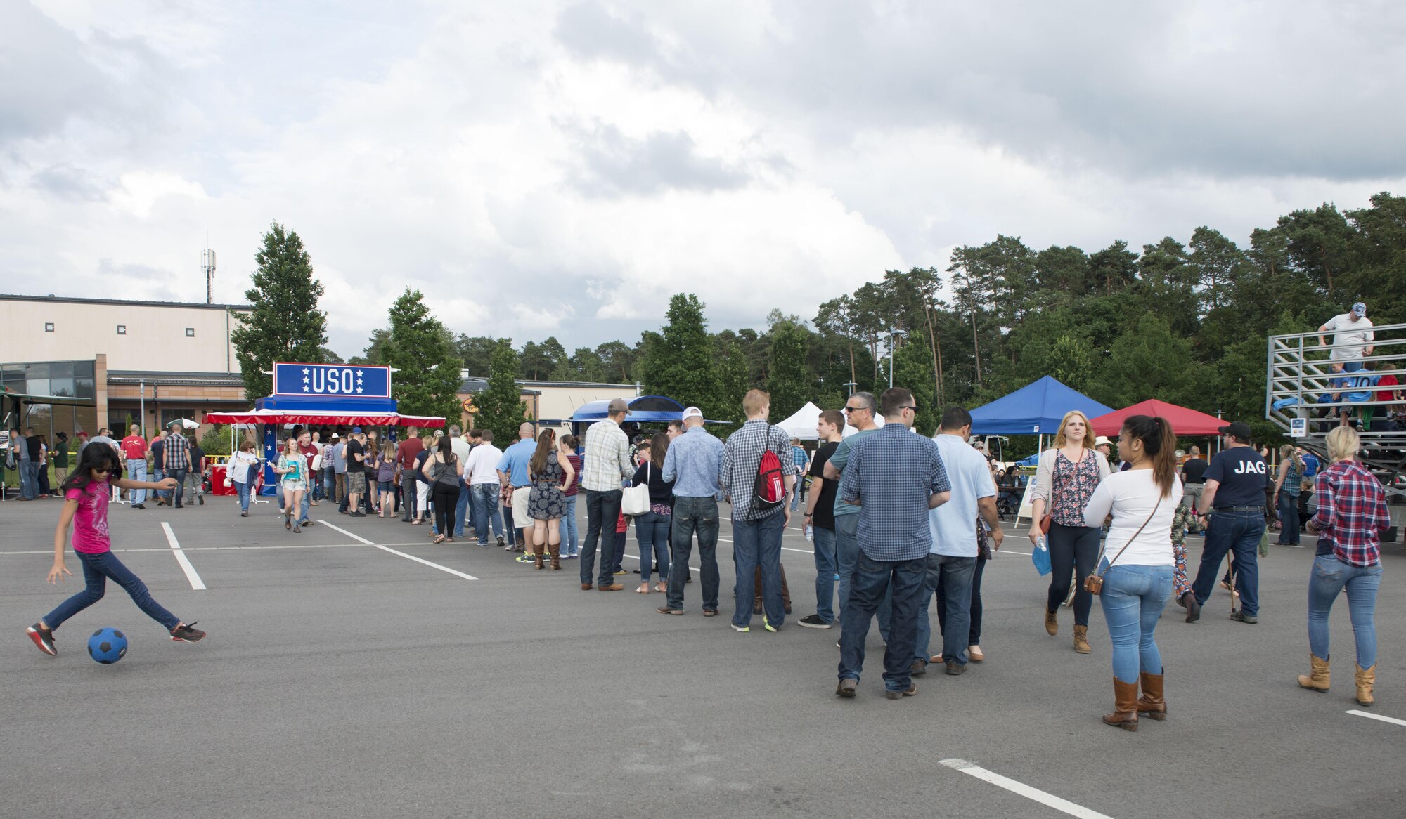 Concertgoers line up for concessions at a USO kiosk while waiting for the performance of Trace Adkins, country music singer, at Ramstein Air Base, Germany, June 11, 2016. The USO-sponsored event was free to all Department of Defense cardholders and their family members. (U.S. Air Force photo/ Airman 1st Class Joshua Magbanua)