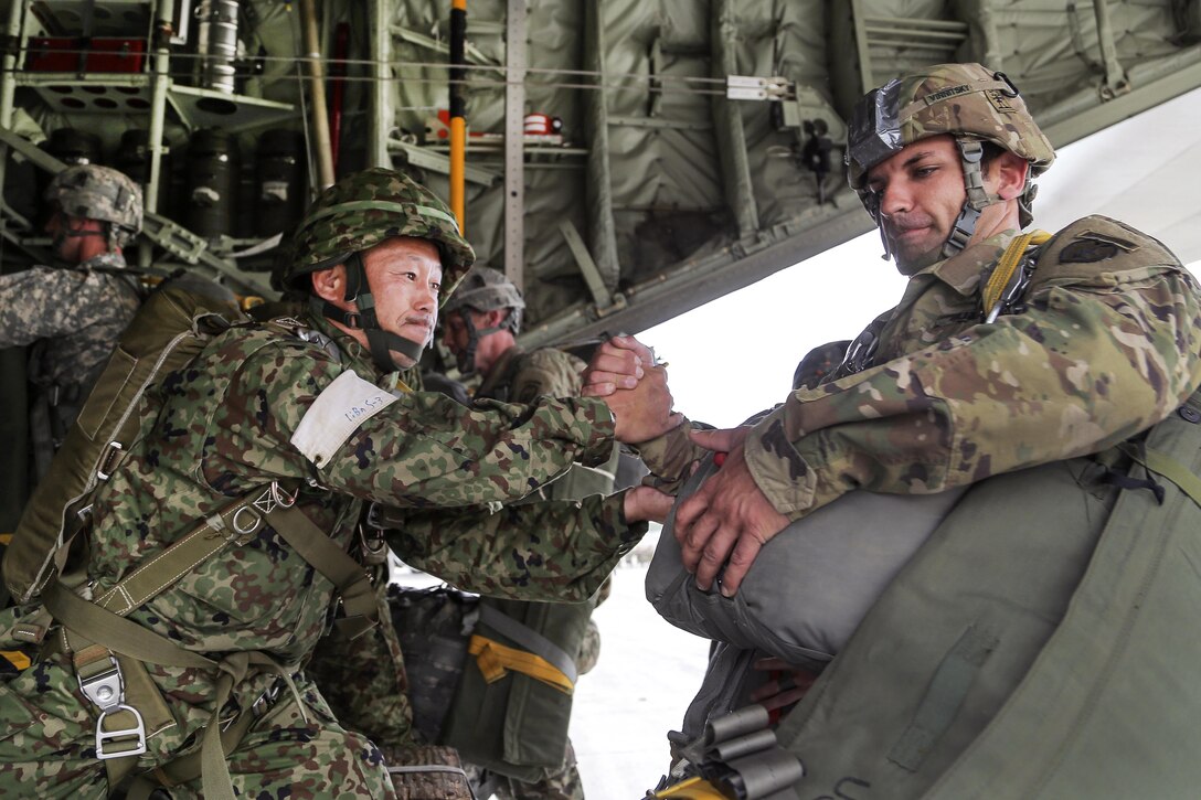 A Japanese army paratrooper, left, helps U.S. Army Spc. Victor Vinnitsky aboard a KC-130J Super Hercules aircraft before participating in an airborne operation during Arctic Aurora 2016 at Joint Base Elmendorf-Richardson, Alaska, June 2, 2016. Vinnitsky is assigned to the 25th Infantry Division’s 3rd Battalion, 509th Parachute Infantry Regiment. Air Force photo by Alejandro Pena