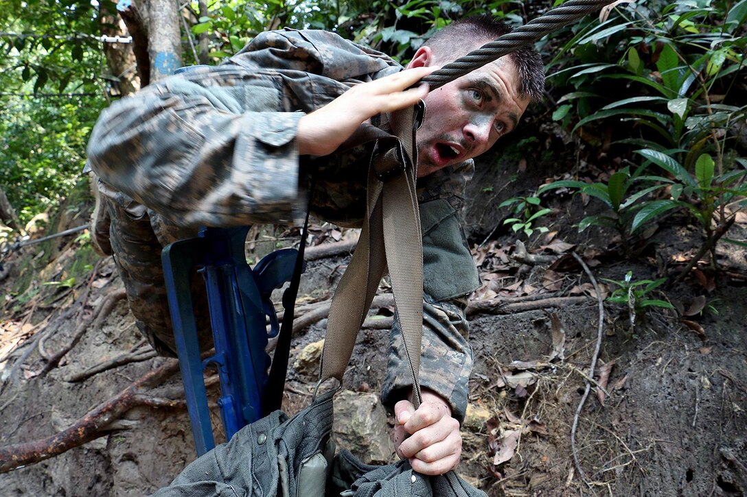 A soldier pushes a weighted rucksack across a cable obstacle at the French jungle warfare school in Gabon, June 9, 2016. Army photo by Staff Sgt. Candace Mundt