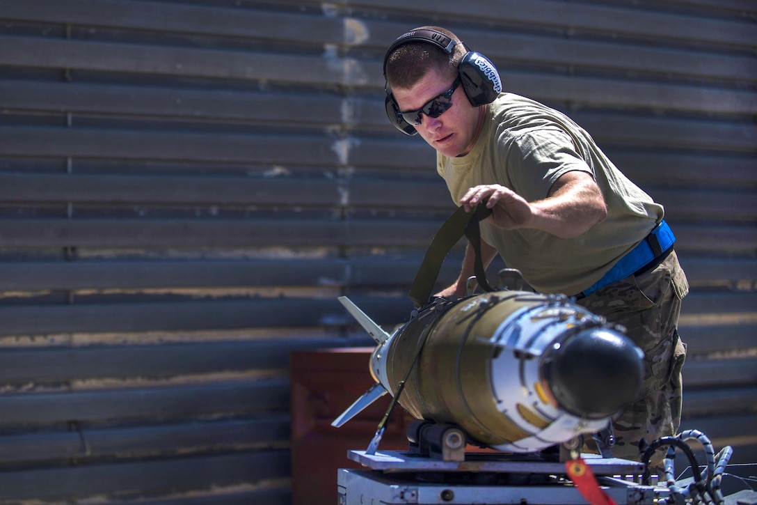 Air Force Tech. Sgt. Joseph McCullough straps a guided bomb to a munitions loader at Bagram Airfield, Afghanistan, June 7, 2016. McCullough is a weapons maintainer assigned to the 455th Expeditionary Aircraft Maintenance Squadron. Air Force photo by Senior Airman Justyn M. Freeman