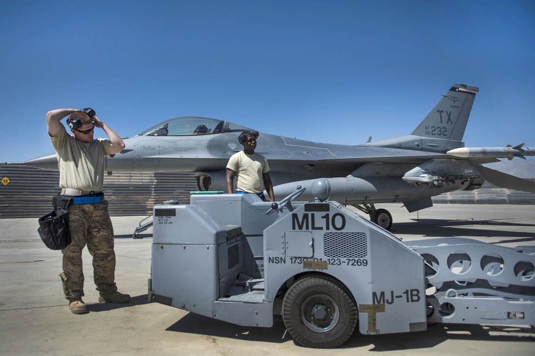 Air Force Tech. Sgt. Joseph McCullough, left, and Senior Airman Clarence Williams prepare to load two guided bombs on an F-16C Fighting Falcon aircraft at Bagram Airfield, Afghanistan, June 7, 2016. McCullough and Williams are weapons maintainers assigned to the 455th Expeditionary Aircraft Maintenance Squadron. Air Force photo by Senior Airman Justyn M. Freeman