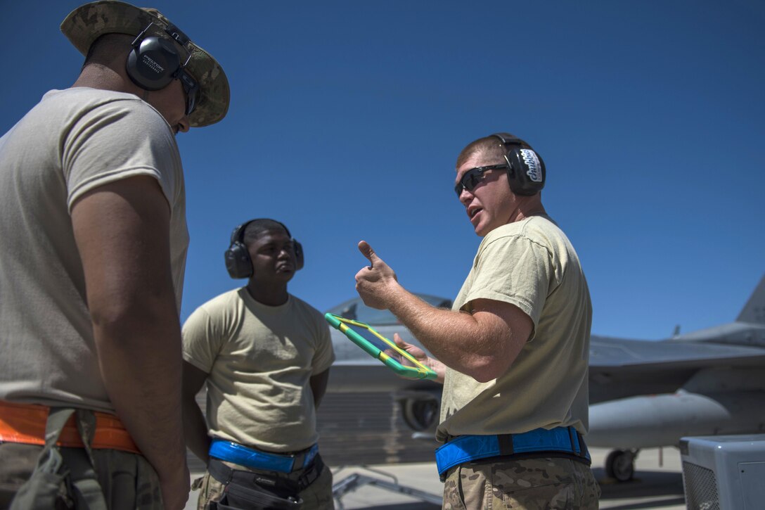 Air Force Technical Sgt. Joseph McCullough, right, gives a weapons briefing to Senior Airman Jorge Martinez, left, and Senior Airman Clarence Williams before loading guided bombs onto an F-16C Fighting Falcon aircraft at Bagram Airfield, Afghanistan, June 7, 2016. McCullough, Martinez and Williams are weapons maintainers assigned to the 455th Expeditionary Aircraft Maintenance Squadron. The weapons team ensures pilots have the correct and functional munitions to provide the air cover ground forces need. Air Force photo by Senior Airman Justyn M. Freeman
