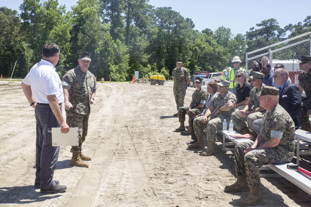 Col. Jeffrey Kenney, back left, the officer-in-charge of Expeditionary Operations Training Group, gives remarks alongside Frank Metallo, special security officer, during the groundbreaking ceremony of the new EOTG facility at Stone Bay, Camp Lejeune, N.C., June 8, 2016. The new facility, slated for completion in March 2017, will feature a simulated entry control point, embassy offices, a tactical exercise control group center and weapons storage. (U.S. Marine Corps photo by Cpl. Paul S. Martinez/Released)