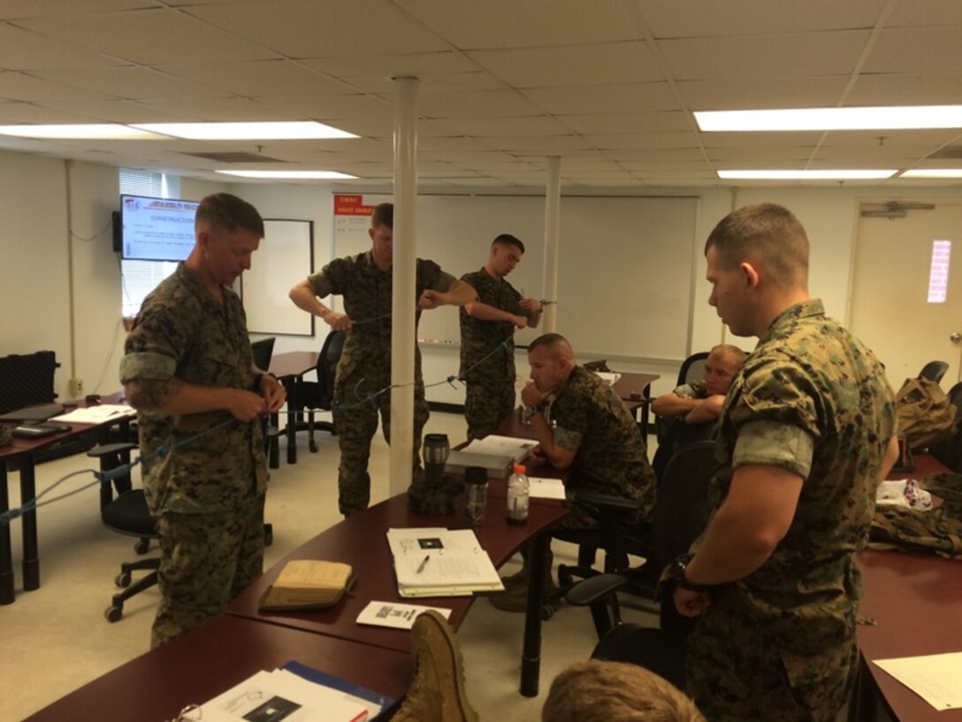 On June 2, 2016 Marines attached to Combat Engineer Officer course 5-16 (CEO 5-16) learned how to tie various knots using detonating cord to breach obstacles in an urban environment. These knots help achieve the maximum impact with explosives used in urban breaching. From left to right are Marine Corps Engineer School (MCES) demolition instructor, Staff Sergeant Andrew Dorf; and CEO 5-16 students Second Lieutenant Nicholas Downey, First Lieutenant Jonathan Lanning Keller, Second Lieutenants Justin Wilkison, Brock Yackey, and Troy Searcy. 
