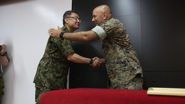 U.S. Marine Col. Eric M. Mellinger, right, shakes hands with Japanese Ground Self-Defense Force Col. Shusei Hotta, June 13, 2016, at Camp Courtney, Okinawa, Japan. Mellinger received a Defense Cooperation Medal from Gen. Kiyofumi Iwata for significantly contributing to increasing training opportunities for the JGSDF by advancing co-use of Marine Corps training facilities on Okinawa and expanding III Marine Expeditionary Force efforts to participate in alliance/bilateral exercises. Hotta is the deputy chief of Policy and Programs Division, Ground Staff Office, JGSDF. Iwata is the JGSDF chief of staff. Mellinger is III MEF chief of staff.